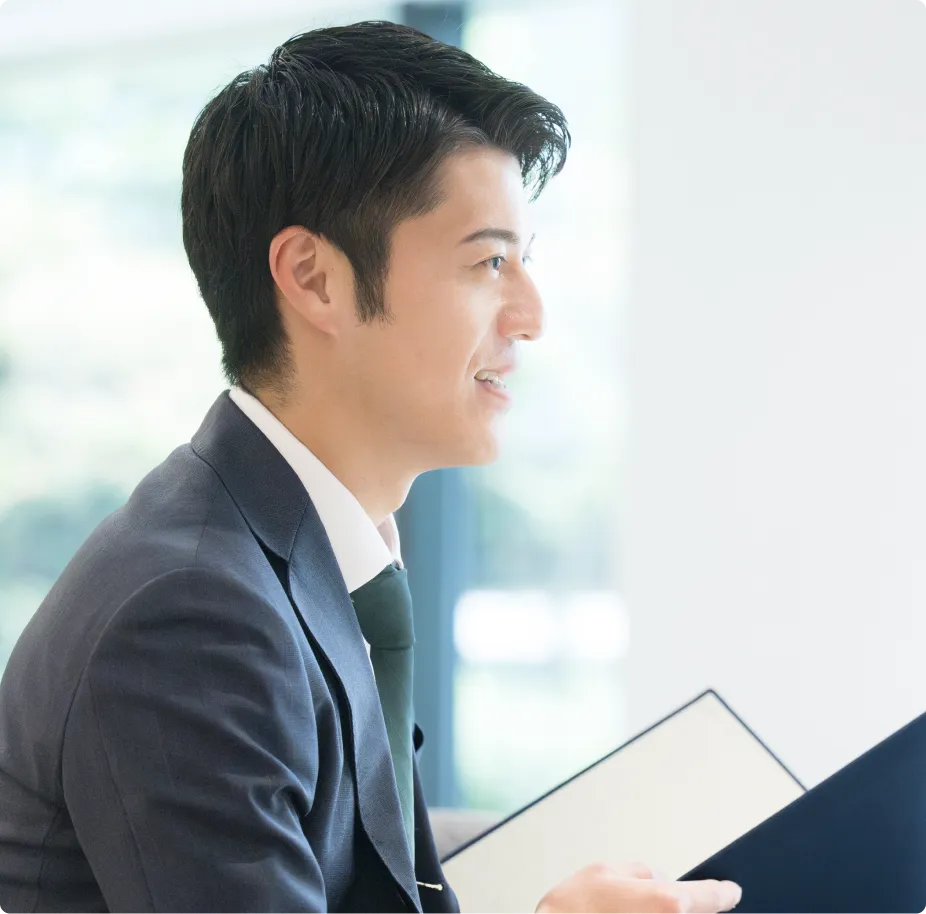 書類を手に会話するスーツ姿の男性