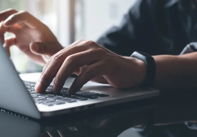 ノートパソコンを操作する手元